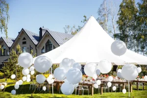 White wedding tent rental set up in a Chicagoland backyard with elegant outdoor reception tables and balloon décor