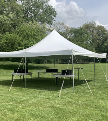 a 20x20 pole tent 48 guest package set up on grass grass with tree's in the background