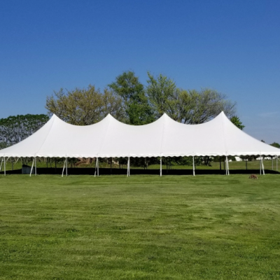 a 40x100 century pole tent with a white top set up at a farm for a festival